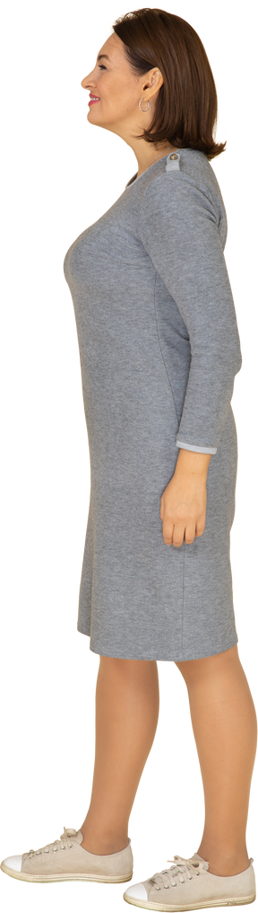 Woman in grey dress standing in profile