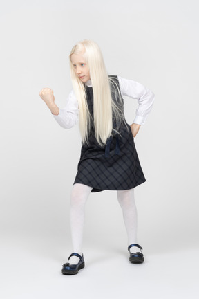 Schoolgirl shaking her fist with hand on waist