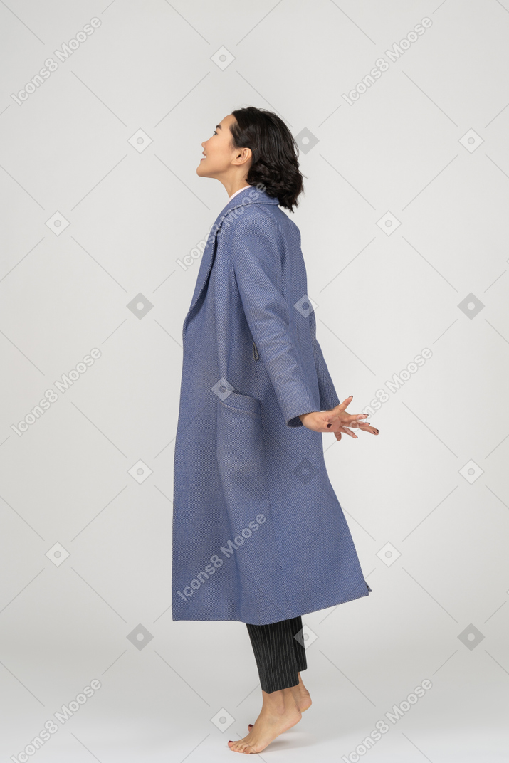 Side view of smiling woman on toes looking up