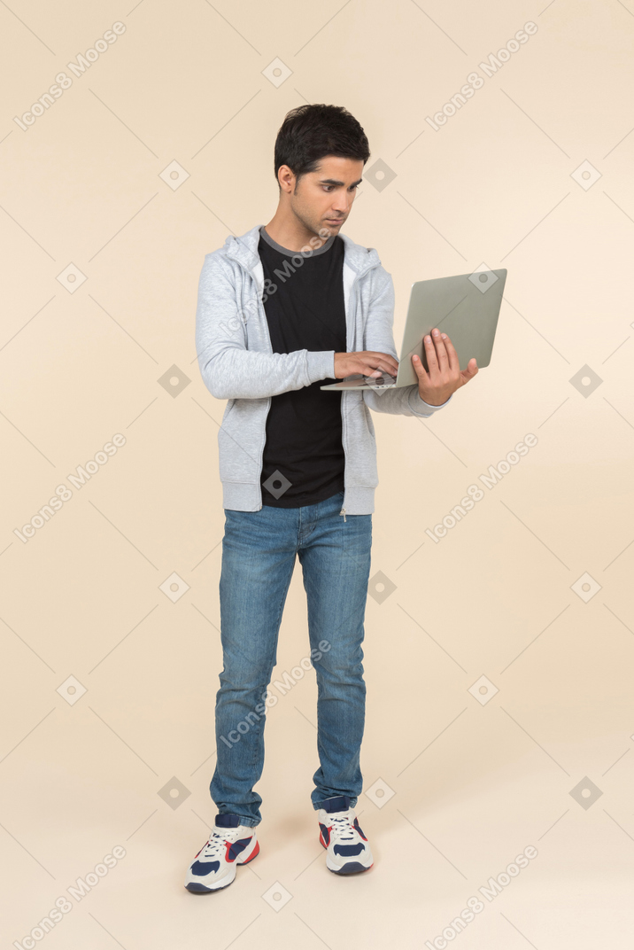 Junger kaukasischer mann, der laptop hält