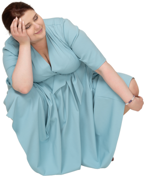 Vue de face d'une femme en robe bleue accroupie