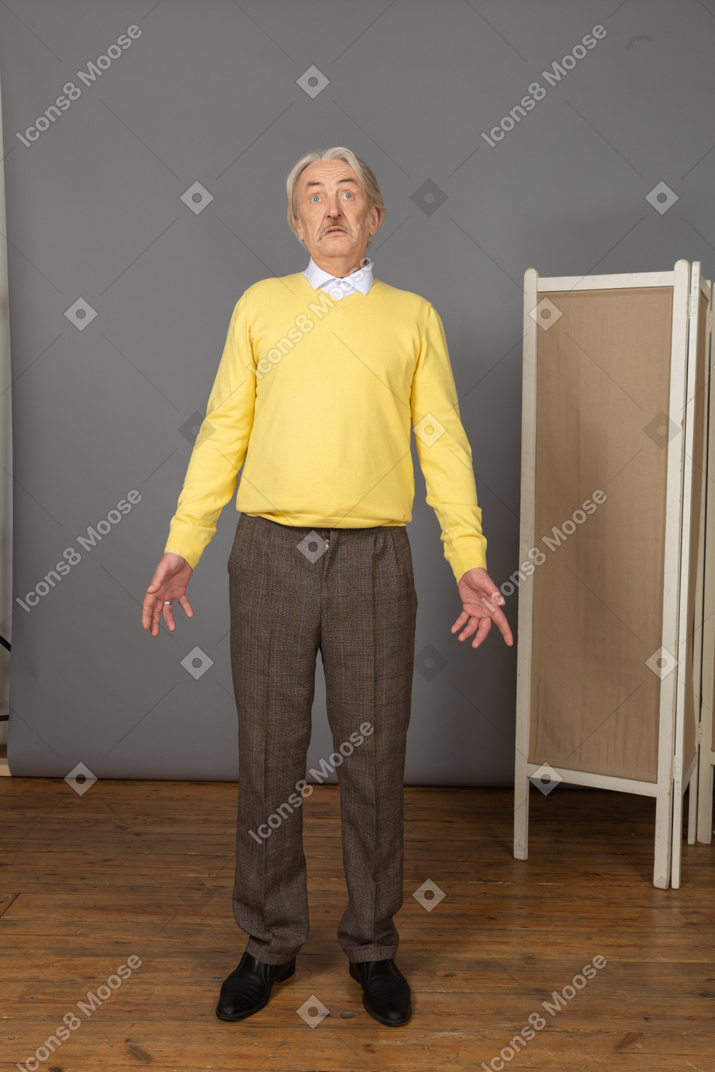 Front view of a staring lost old man outspreading hands