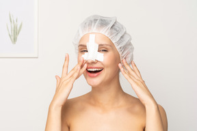 Portrait of smiling woman with bandage on her nose after plastic surgery