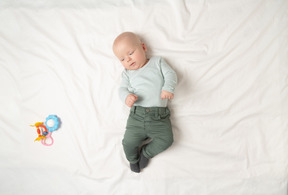 Petit garçon couché sur le dos et regardant sur les jouets