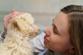 Hembra joven caricias con su pequeño caniche