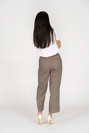 Vista posterior de una mujer joven en calzones cruzando las manos