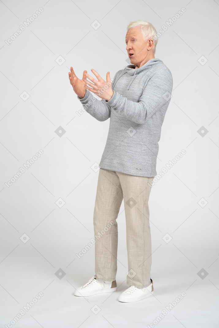 Вид в три четверти на потрясенного мужчину с растопыренными пальцами