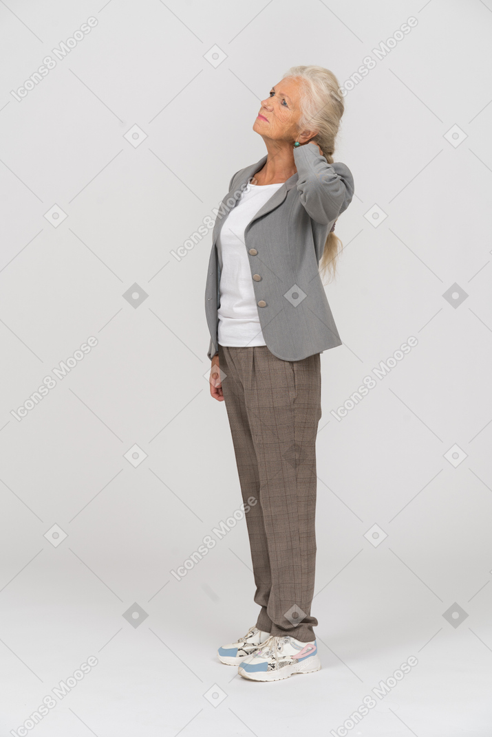 Vista lateral de una anciana en traje tocando su cuello