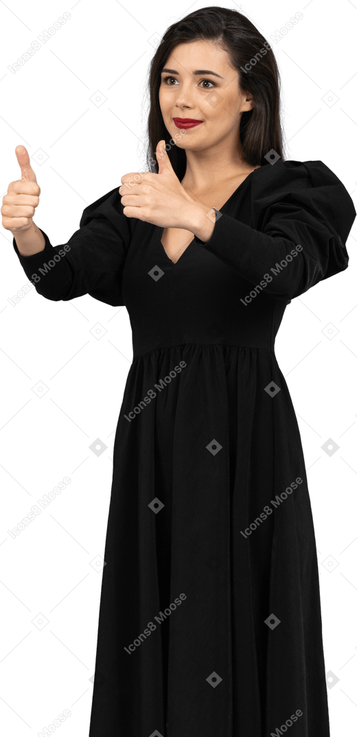 Vista di tre quarti di una giovane donna sorridente in un abito nero che mostra i pollici in su