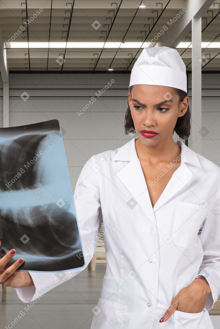 Ein besorgter arzt, der die röntgenaufnahme der brust betrachtet