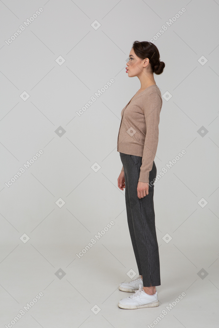 Side view of a pouting lady in pullover and pants looking aside