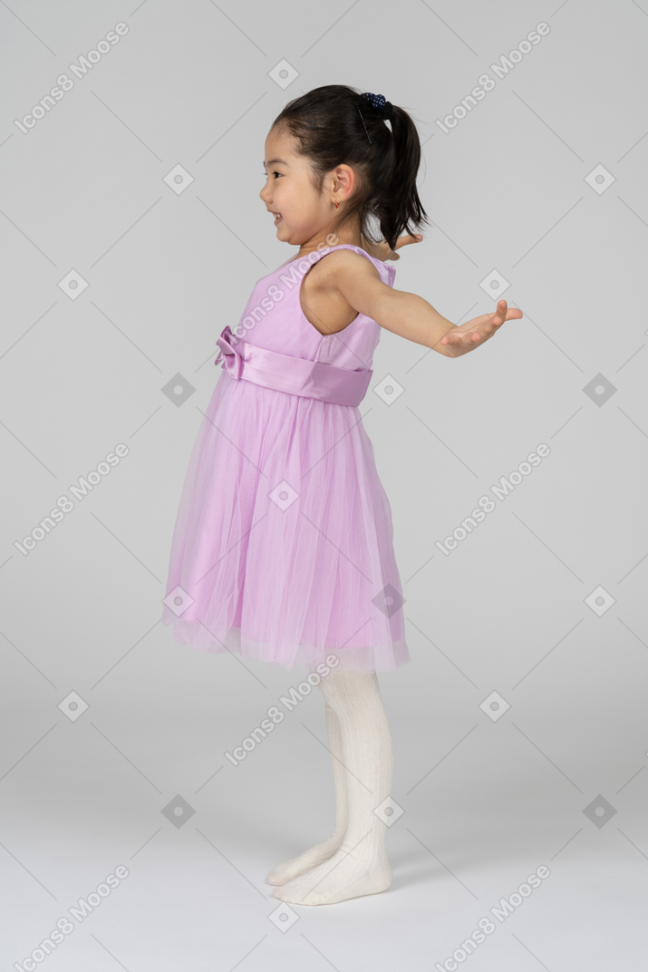 Little girl in pink dress welcoming somebody with spread arms