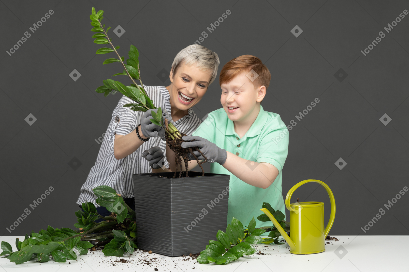 Mother and son taking care of home flowers