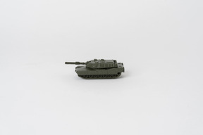 A side shot of a toy tank standing against a plain white background