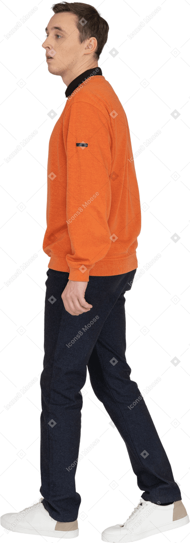 Young man in orange sweatshirt walking