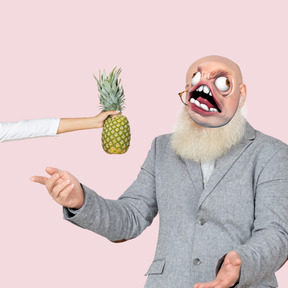 Man with rage meme face pointing at pineapple