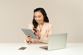 Empregado de escritório feminino asiático olhando para tablet