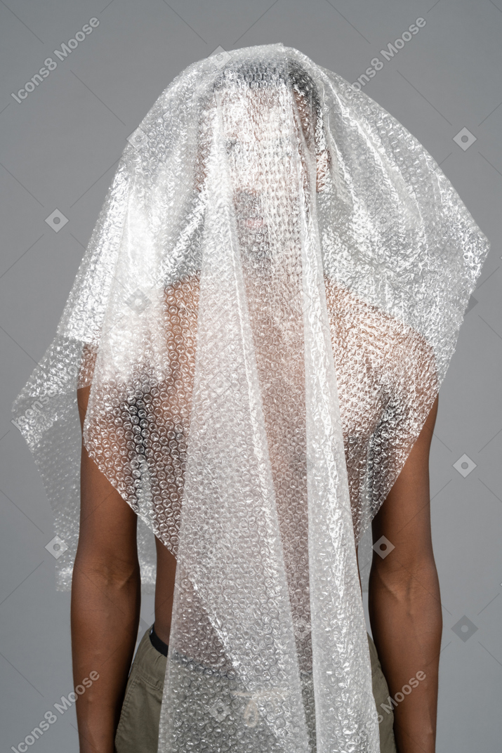 Close-up unrecognizable african male hiding under plastic wrap