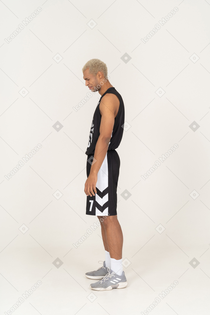 Vista lateral de un joven jugador de baloncesto masculino retirado