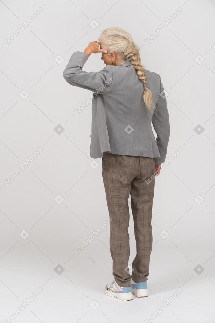 Rear view of an old lady in suit looking for someone
