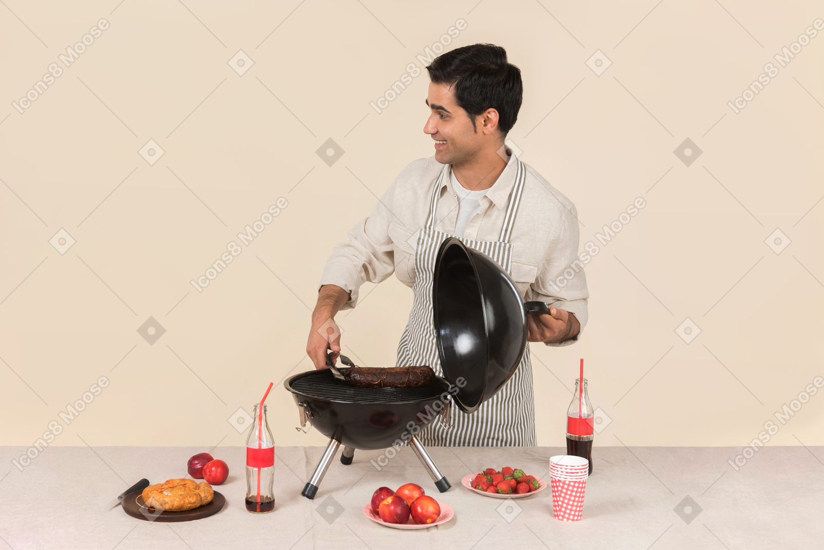 Улыбающийся молодой человек кавказской приготовления барбекю