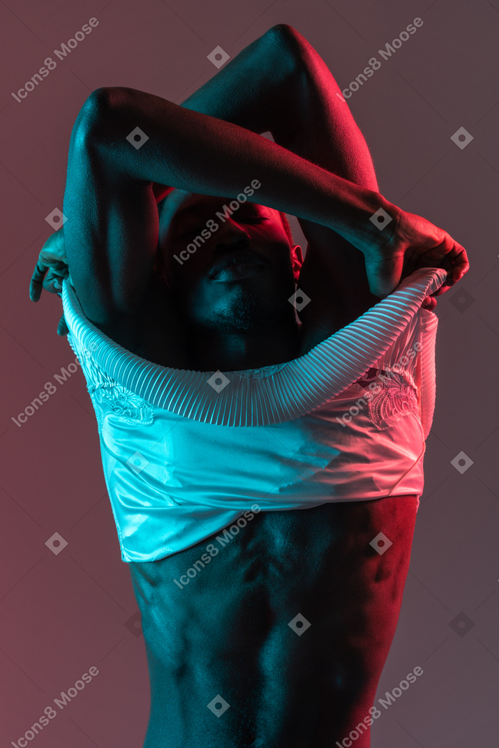 Black young man taking off his nightie