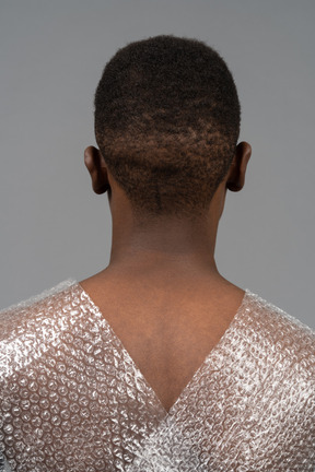 Head to shoulders back portrait of an african man wrapped in plastic