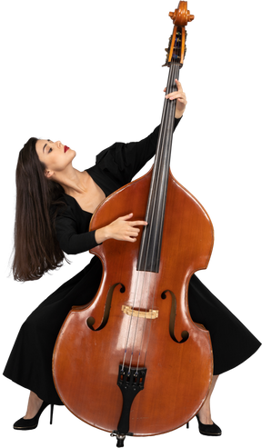 Front view of a graceful squatting young lady standing behind her double-bass