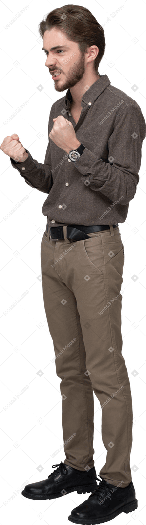 Three-quarter view of a furious man in office clothing clenching fists