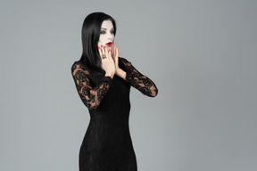 Morticia addams gasping and covering her face with hand a little
