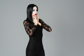 Morticia addams haletant et couvrant son visage avec la main un peu