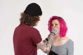 Young man sticks a yellow plaster on his girlfriend's nose