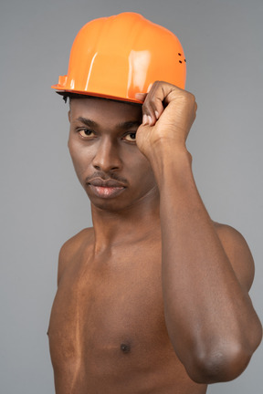 A shirtless young man wearing a safety helmet