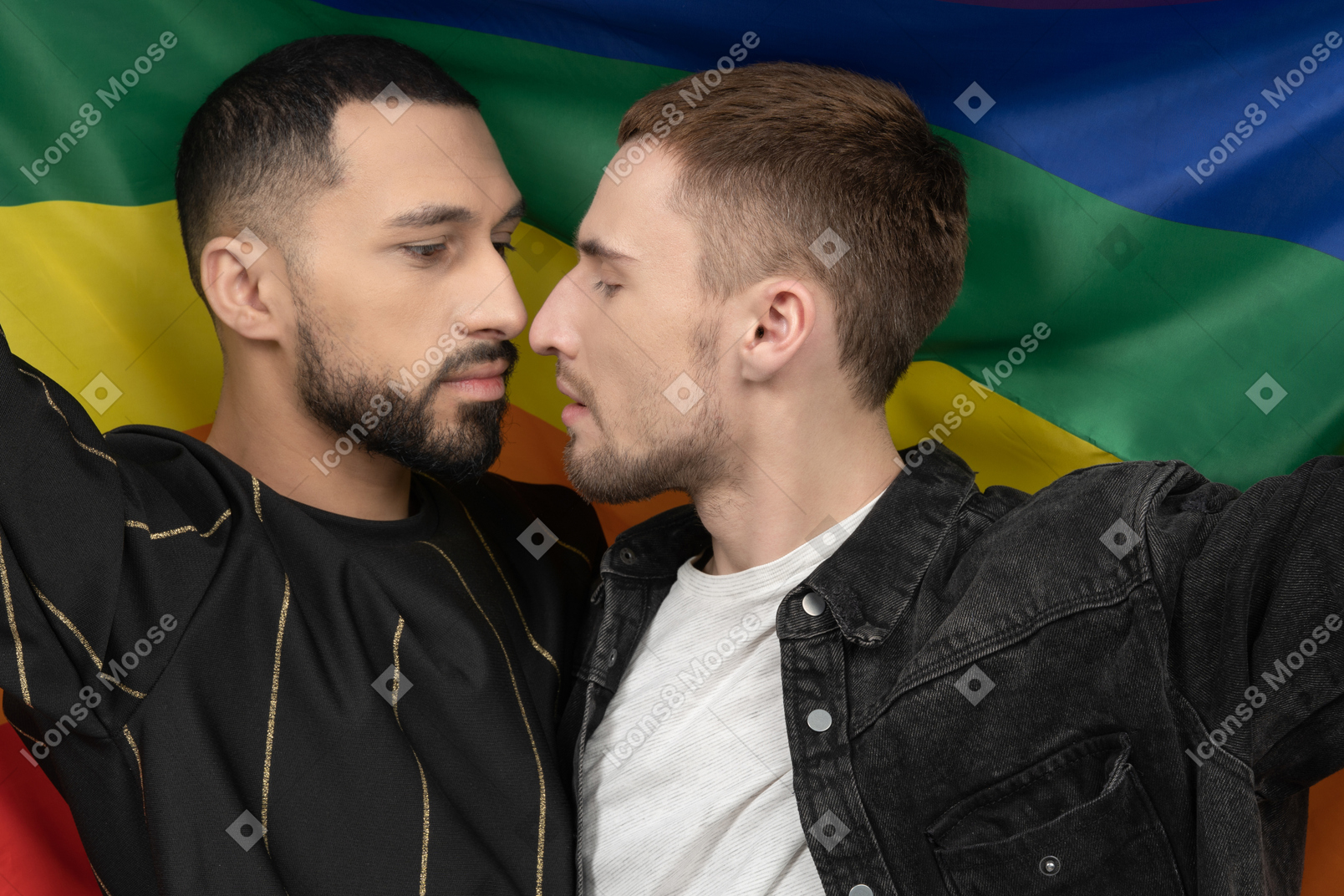 Close-up of two young men holding lgbt flag and touching noses sensually