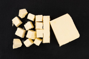 Cut block of butter on black background