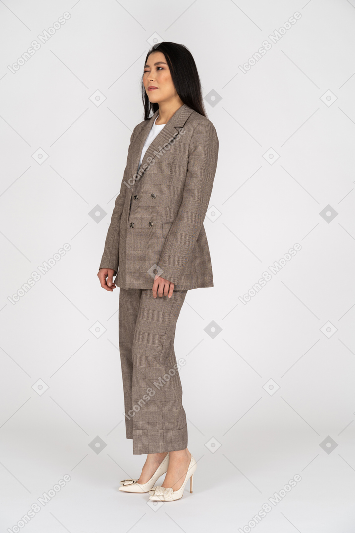 Three-quarter view of a winking young lady in brown business suit