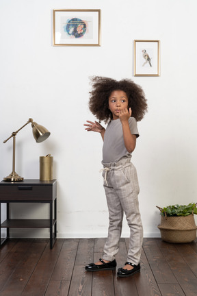 Good looking girl kid posing on the apartment background