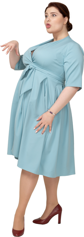 Vista lateral de uma mulher de vestido azul gesticulando