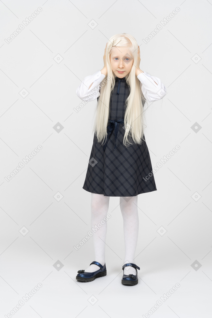 Long-haired schoolgirl covering her ears
