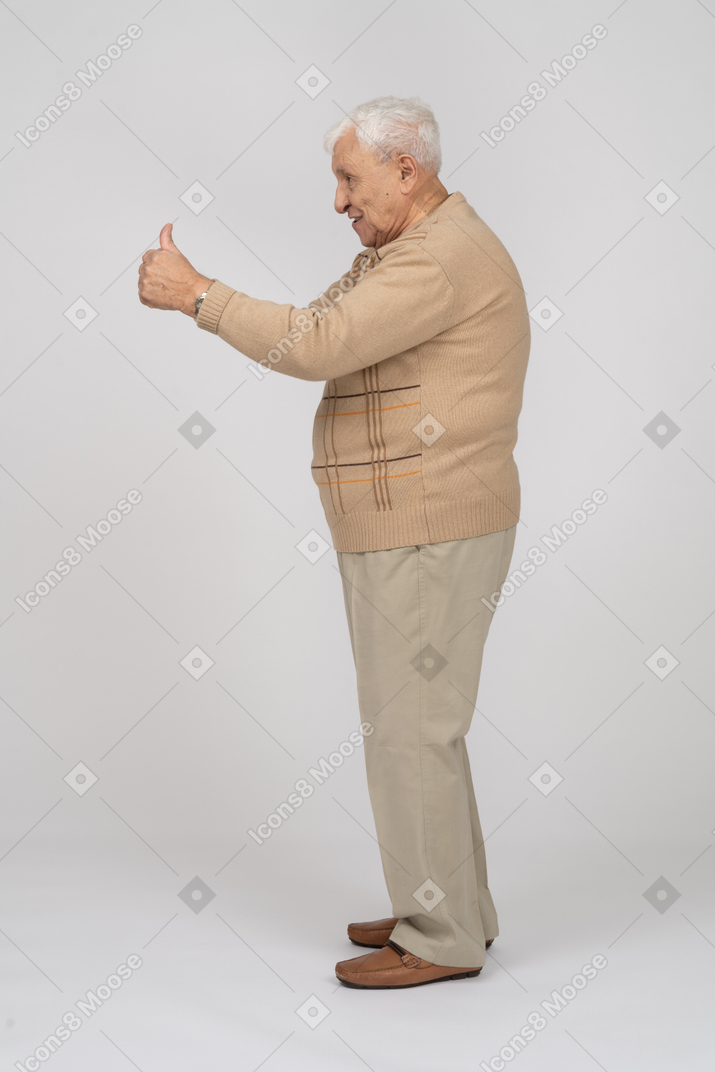 Vista laterale di un vecchio in abiti casual che mostra il pollice in su