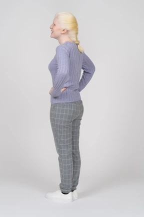 Smiling young woman standing with her hands on her hips