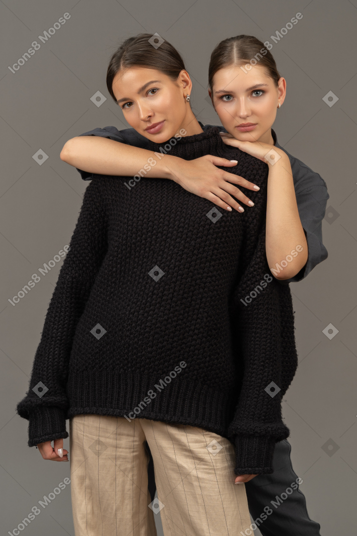 Две женщины обнимаются и смотрят в камеру