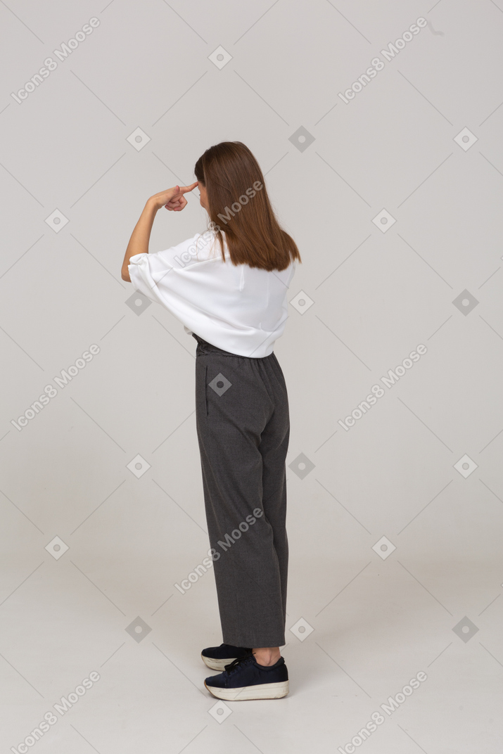 Three-quarter back view of a young lady in office clothing touching head