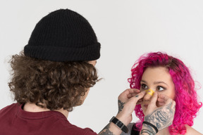 Close-up a man sticking a plaster on his girlfriend's nose