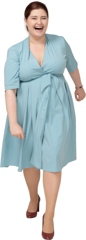 Vista frontale di una donna felice in abito blu che cammina