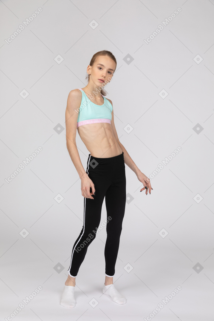 Three-quarter view of a teen girl in sportswear tilting shoulders