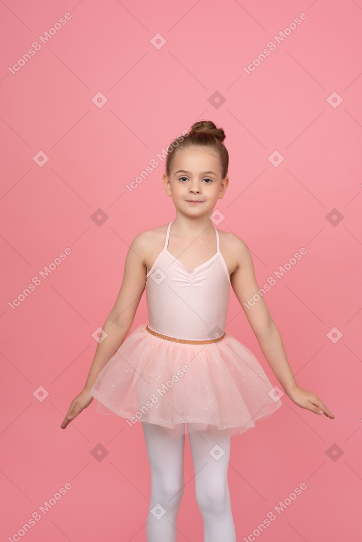 Cute little ballerina standing with her hands aside