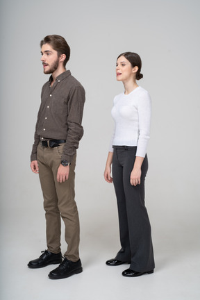 Three-quarter view of a young couple in office clothing showing tongue