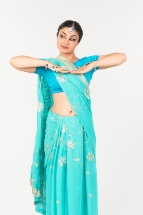 Jeune femme indienne en sari bleu debout en position de danse