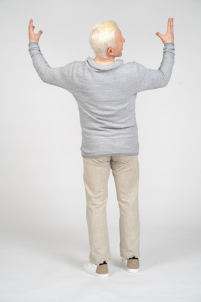 Vista posteriore di un uomo in piedi con le braccia alzate